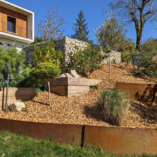 Bordure paysagère en Acier Corten Maroc intégrée à un jardin en pente avec végétation et aménagement extérieur contemporain.