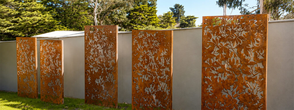 Claustras décoratifs ajourés en Acier Corten Maroc avec motifs végétaux installés dans un jardin contemporain.