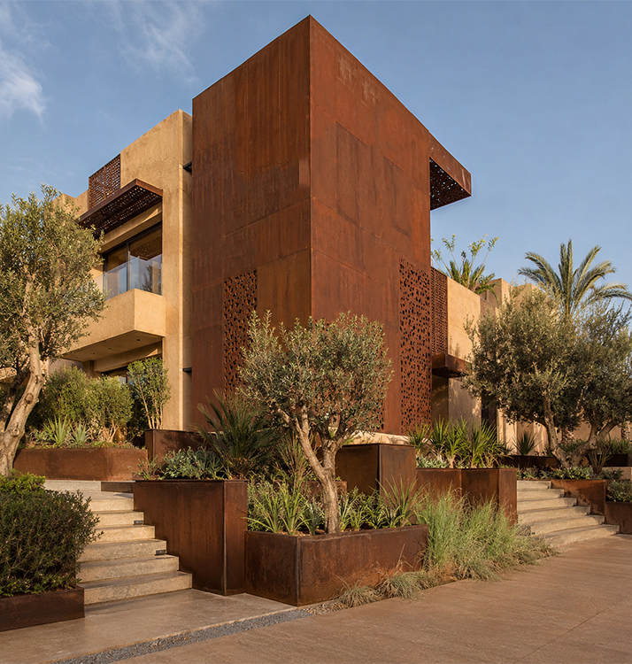 Façade contemporaine en Acier Corten Maroc avec jardinières sur mesure et aménagement paysager dans une villa haut de gamme.