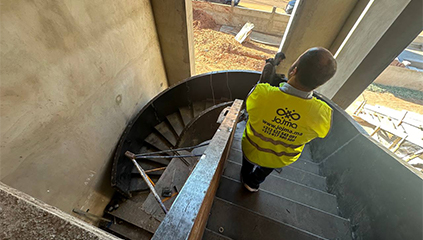 Technicien réalisant l’installation d’un escalier hélicoïdal métallique sur chantier dans le cadre d’un projet Acier Corten Maroc.