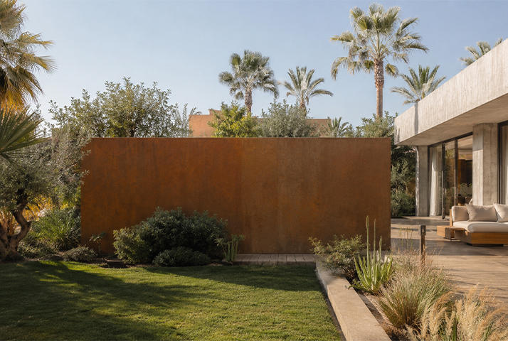Mur brise-vue en Acier Corten Maroc intégré au jardin paysager d’une villa contemporaine avec palmiers et végétation.