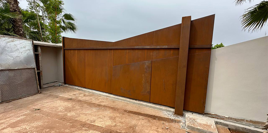 Portail coulissant sur mesure en Acier Corten Maroc installé à l’entrée d’une villa contemporaine.