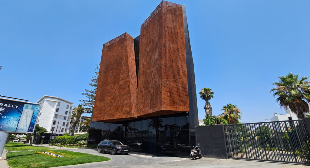 Façade monumentale avec panneaux perforés intégrée à des Projets en acier Corten sur un bâtiment contemporain.
