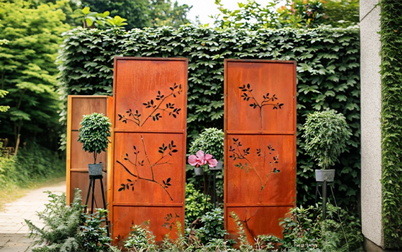 Claustras décoratifs à motifs végétaux installés dans le jardin d’une villa parmi nos Réalisations en acier Corten.